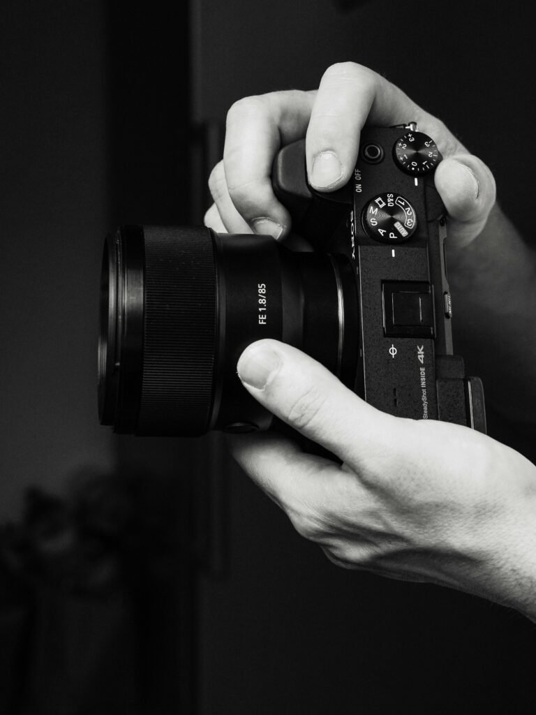 Portrait photographer using a mirrorless camera to capture natural light portraits